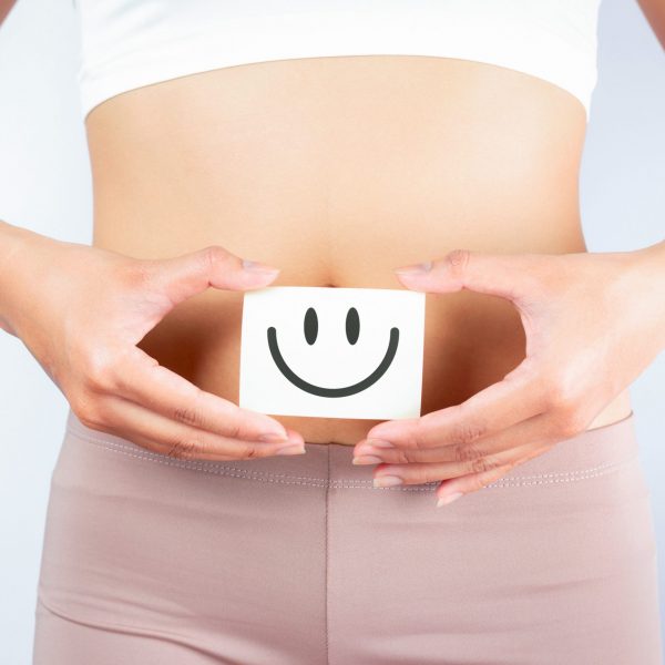 Women Stomach Health. Healthy Female With Beautiful Fit Slim Body  Holding White Card With Happy 
Smiley Face In Hands Good Digestion Concepts. High Resolution